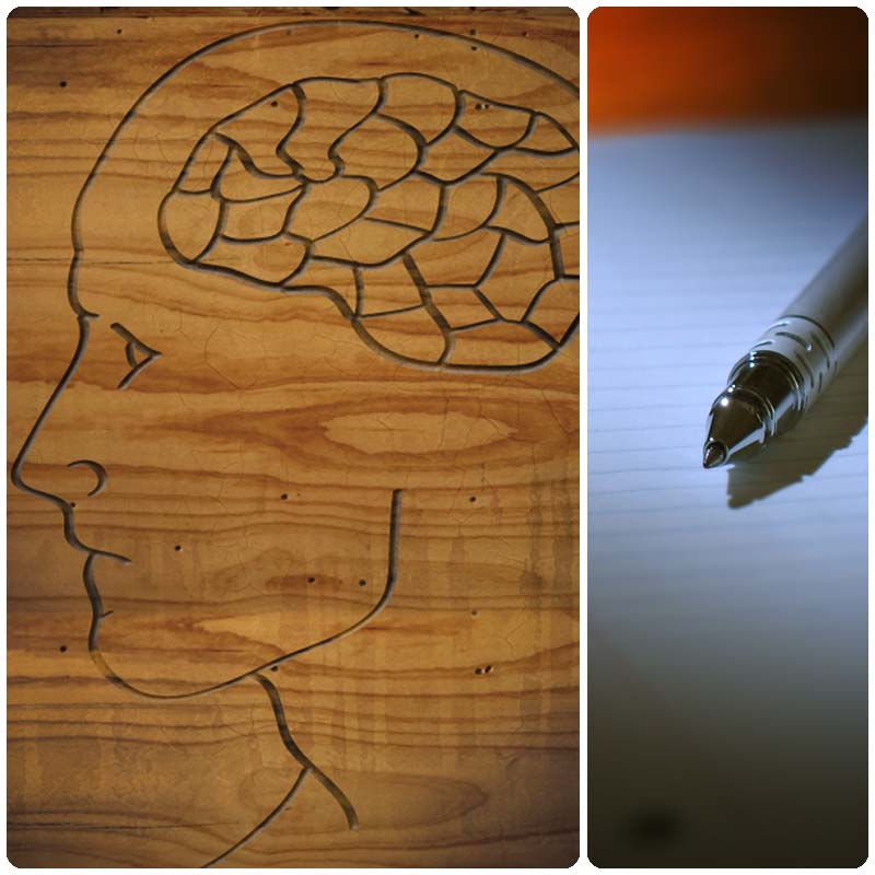 A wooden art piece showing a person's brain and a pen on paper.